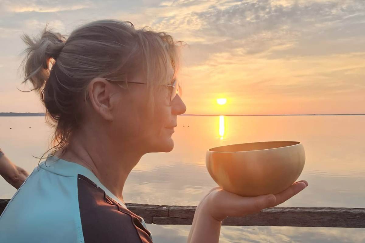 Ina Cladow mit Klangschale im Abendlicht