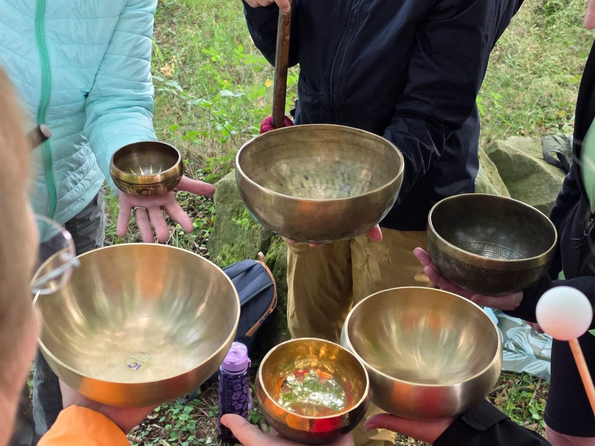 Frauen halten Klangschalen im Kreis