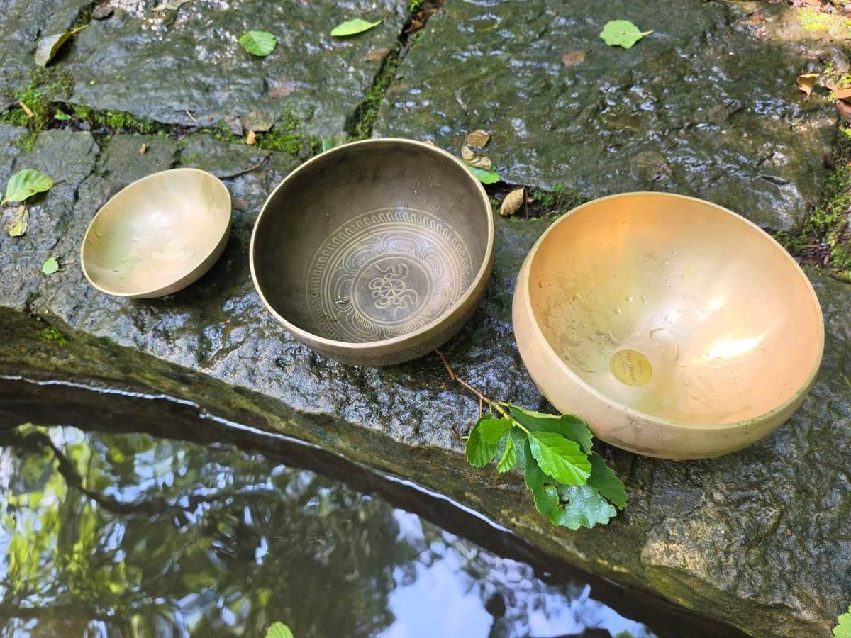 Drei Klangschalen am Wasser