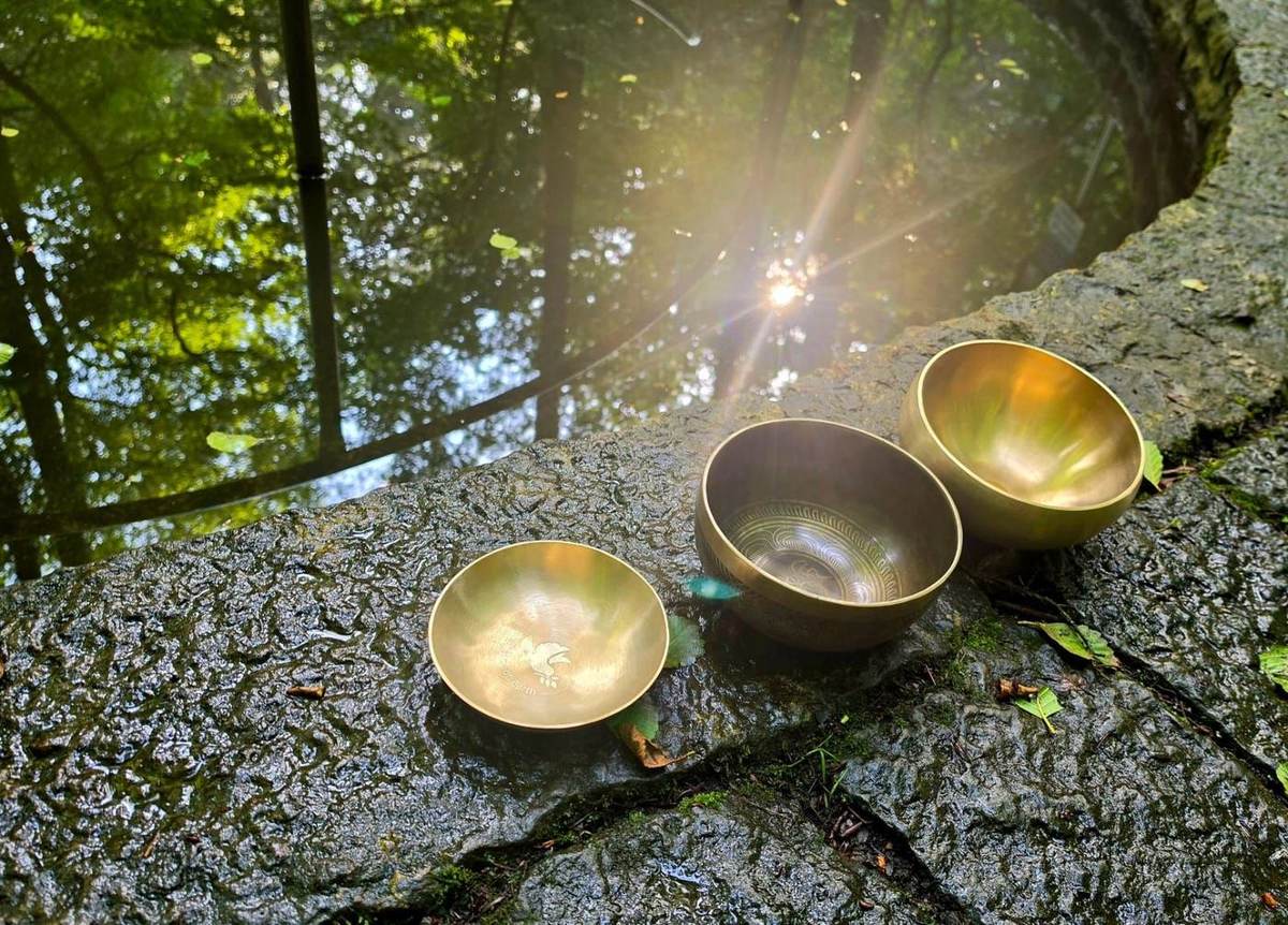 Klangschalen im Sonnenlicht am Wasser